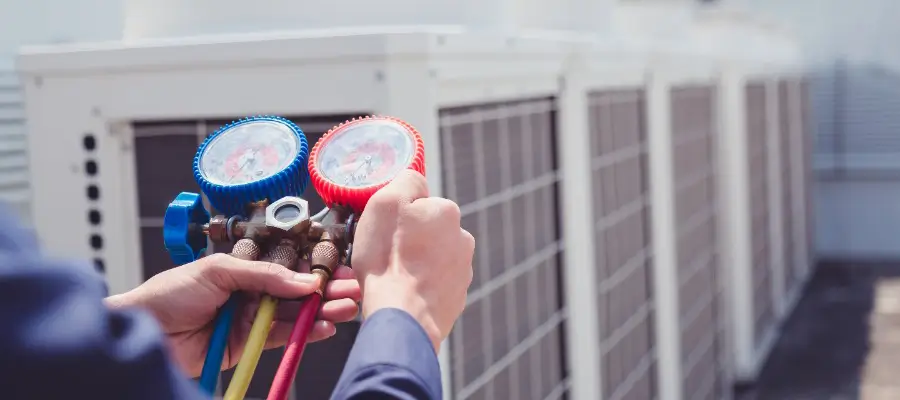 HVAC technician adjusting gauges on a system
