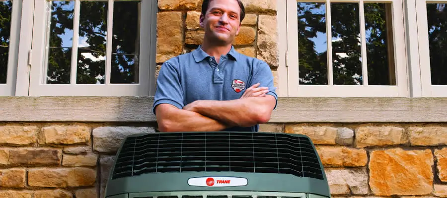 Ductworks dealer standing behind a Trane heat pump